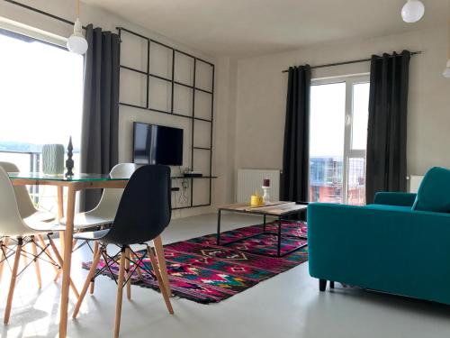a living room with a table and a blue couch at Cluj Apartments in Cluj-Napoca