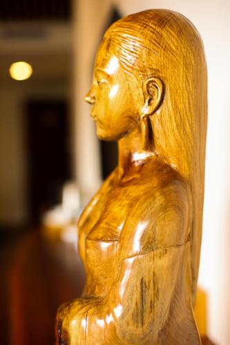 a wooden statue of a woman with her arms crossed at Ridge Inn in Longsheng