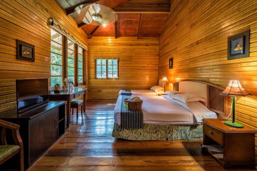 een slaapkamer met een groot bed in een houten kamer bij Borneo Tropical Rainforest Resort in Kampong Butir