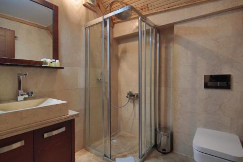 a bathroom with a shower and a toilet and a sink at Aden Hotel Cappadocia in Uçhisar