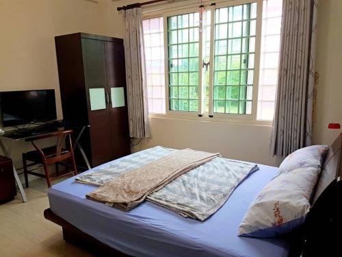 a bedroom with a bed and a window and a television at Emerald Grange in Gongguan