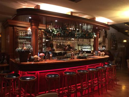 een bar met rode krukken in een restaurant bij Kerkplein Vakanties in Vrouwenpolder