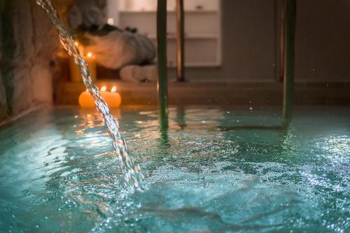 a stream of water pouring into a swimming pool at S'Hotelet d'es Born - Suites & SPA in Ciutadella