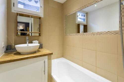 uma casa de banho com um lavatório e um espelho em Apartment Triolet Jardin em Chamonix-Mont-Blanc