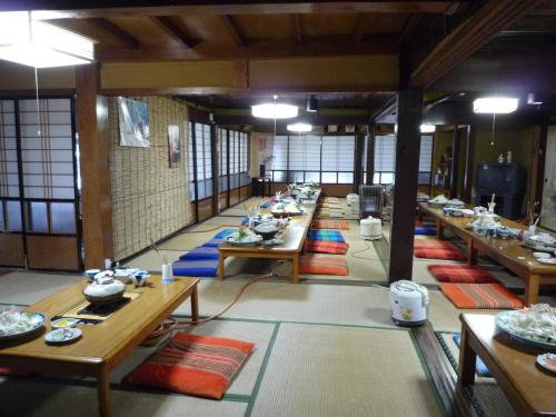 una fila de mesas en una habitación con mesas y sillas en Yonagoya, en Kami
