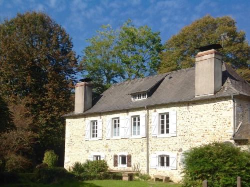 una antigua casa de piedra con techo negro en Gite-Holiday Home Au Moulin 1771 en Monein