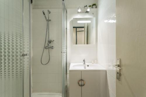 y baño blanco con lavabo y ducha. en Apartment Chamois Blanc 1, en Chamonix-Mont-Blanc