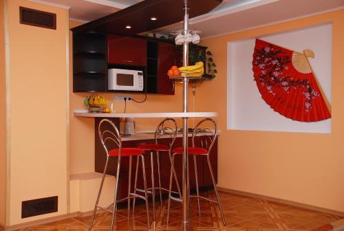 a kitchen with a bar with stools and a microwave at House in Bohatyrska street in Kyiv
