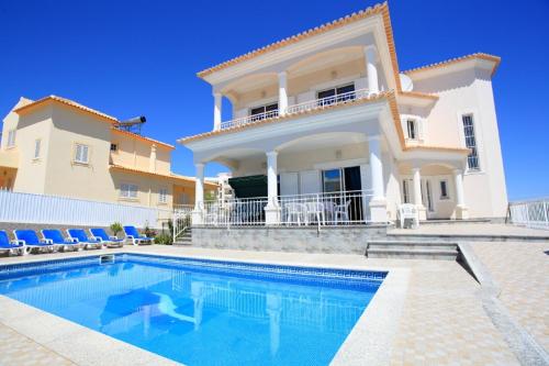 a villa with a swimming pool in front of a house at Vivenda Luz - Jacuzzi & Swimming Pool in Albufeira