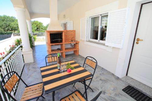 a patio with a table and chairs and a fireplace at Vivenda Luz - Jacuzzi & Swimming Pool in Albufeira
