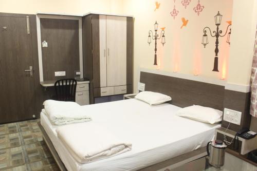 - une chambre avec un grand lit blanc dans l'établissement Hotel Kwality Inn, à Satna