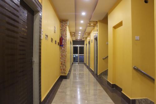 a hallway of a hospital with yellow walls and a hallway at Hotel Kwality Inn in Satna