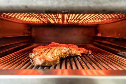 a piece of meat cooking on a grill in an oven at Brauers Landarthotel GmbH in Daun