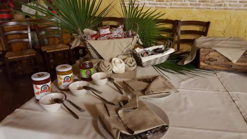 a table with a white table cloth with cups and utensils at Agriturismo La Maddalena in Acate