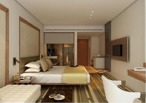 a bedroom with a large bed and a living room at Sayaji Vadodara in Vadodara