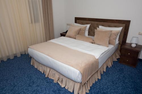 a neatly made bed in a hotel room at Faria Boutique Hotel in Tsaghkadzor