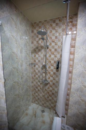 a shower in a bathroom with a tiled wall at Faria Boutique Hotel in Tsaghkadzor
