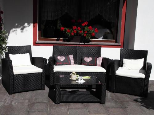 two wicker chairs and a table on a patio at Hotel Garni Walter in Ortisei