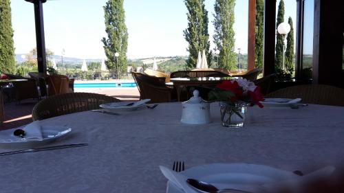 a table with a white table cloth and a vase of flowers on it at Agriturismo La Sovana in Sarteano