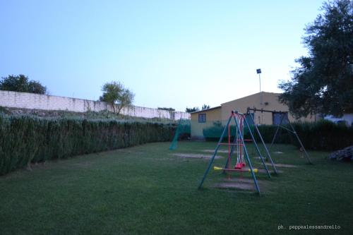 a yard with a swing set in the grass at Agriturismo La Maddalena in Acate