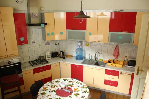 una cocina con armarios rojos y blancos y una mesa en New York Hostel en Leópolis