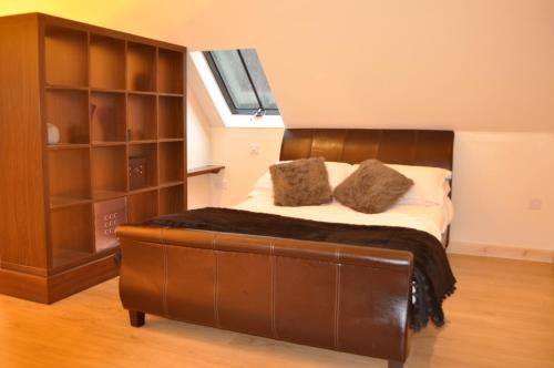 een slaapkamer met een groot bed met een bruin hoofdeinde bij Finlaystone Barns in Port Glasgow