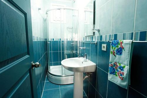 イスタンブールにあるBlue Suites by Vの青いタイル張りのバスルーム(シンク、シャワー付)