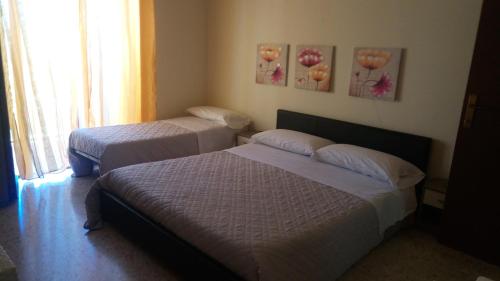 a bedroom with two beds and a window at lovelybed in Aprilia