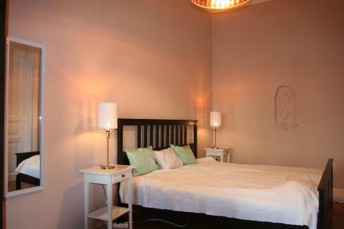 um quarto com uma cama com 2 candeeiros e um espelho em Diamonds Apartment with 2 rooms near Guzsdu udvar em Budapeste