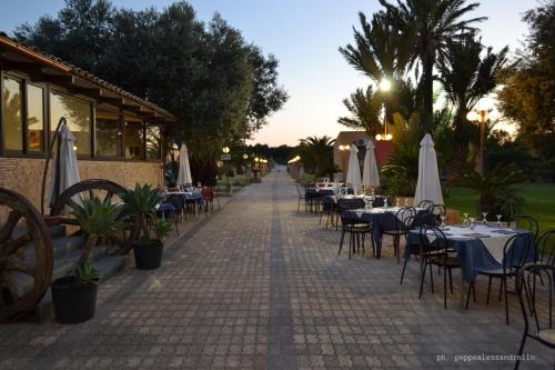 an empty street with tables and chairs and umbrellas at Agriturismo La Maddalena in Acate