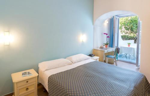 a bedroom with a bed and a window and a sink at Hotel Costa Citara in Ischia