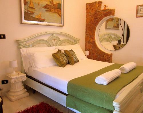 a hotel room with a bed, desk, and mirror at Villa Ambra B&B in Noto