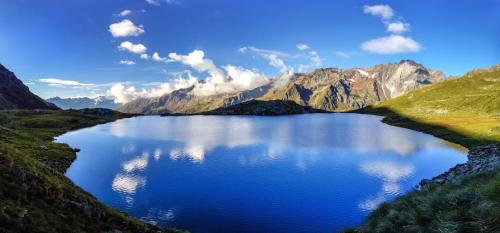 a lake in the middle of a mountain range at Hotel Garni Pegrà in Ponte di Legno