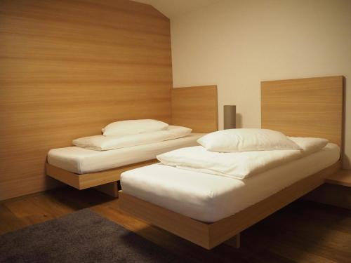 two twin beds in a room with wooden walls at Hotel Gasthof Wieser in Petersberg