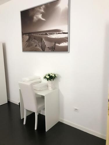 Vacation Venice Rooms في ميستر: طاولة بيضاء وكراسي مع صورة على الحائط