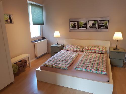 1 dormitorio con 1 cama con 2 almohadas y 2 lámparas en Haus Homann-Schneider, Wohnung Wetter, en Wetter