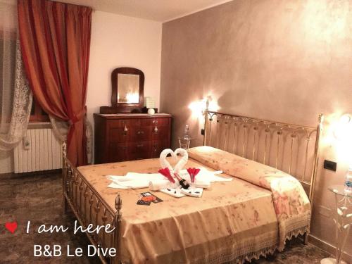 a bedroom with a bed with two swans on it at B&B Le Dive in Ostra