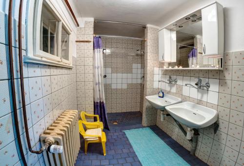 a bathroom with a yellow chair and a sink at Chata Advokátka in Janske Lazne