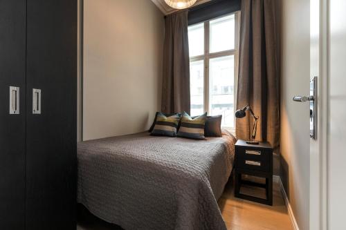 Josefinesgate Apartments في أوسلو: غرفة نوم بسرير ومخدات ونافذة