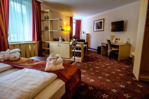ハーネンクレー・ボックスヴィーゼにあるWalpurgishofのベッド2台とデスクが備わるホテルルームです。
