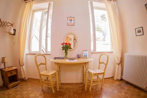 フォワにあるラルシュ デ シャプリエのテーブル、椅子、鏡が備わる客室です。