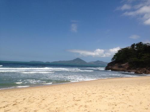 a sandy beach with a view of the ocean at Kitnets & Flats in Ubatuba