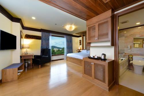 a hotel room with a bed and a bathroom at Peak Nimman Prestige Hotel in Chiang Mai