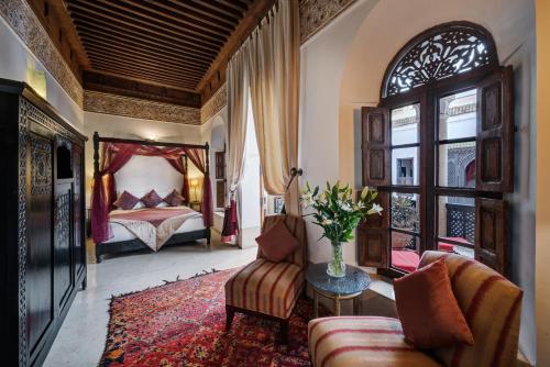 a bedroom with a bed and a couch and a table at Riad Azzar in Marrakesh