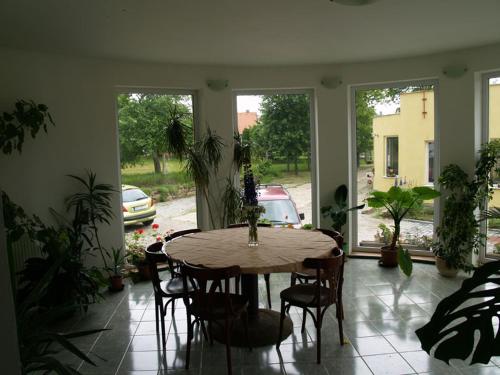 a table and chairs in a room with windows at Pension Pod Šibeňákem in Strmilov