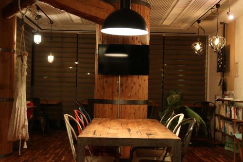 a dining room with a wooden table and chairs at 365BASE outdoor hostel in Hamamatsu