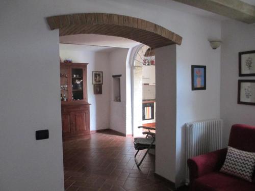 a living room with an archway and a dining room at Casa Valeria in Cinigiano