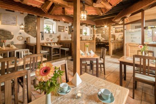 a restaurant with wooden tables and chairs in a room at Schlosshotel Klaffenbach in Chemnitz