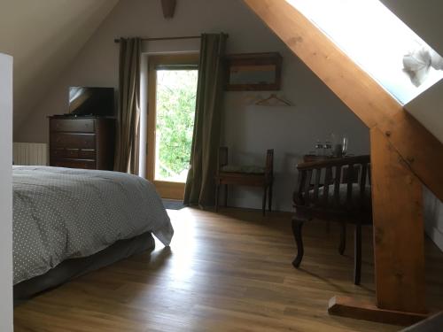 a bedroom with a bed and a dresser and a window at L'auberge du Mont in Le Breuil-en-Auge