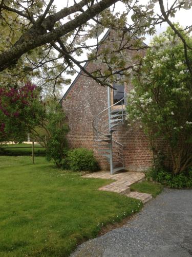 a brick building with a staircase on the side of it at L'auberge du Mont in Le Breuil-en-Auge